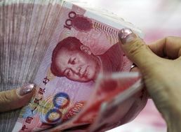 Bankový úradníčka ráta čínske bankovky v pobočke banky v čínskom meste Chuaj-pej