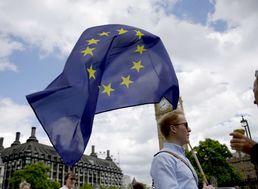 Na snímke priaznivec Európskej únie s vlajkou EÚ prechádza okolo budovy britského partlamentu v Londýne